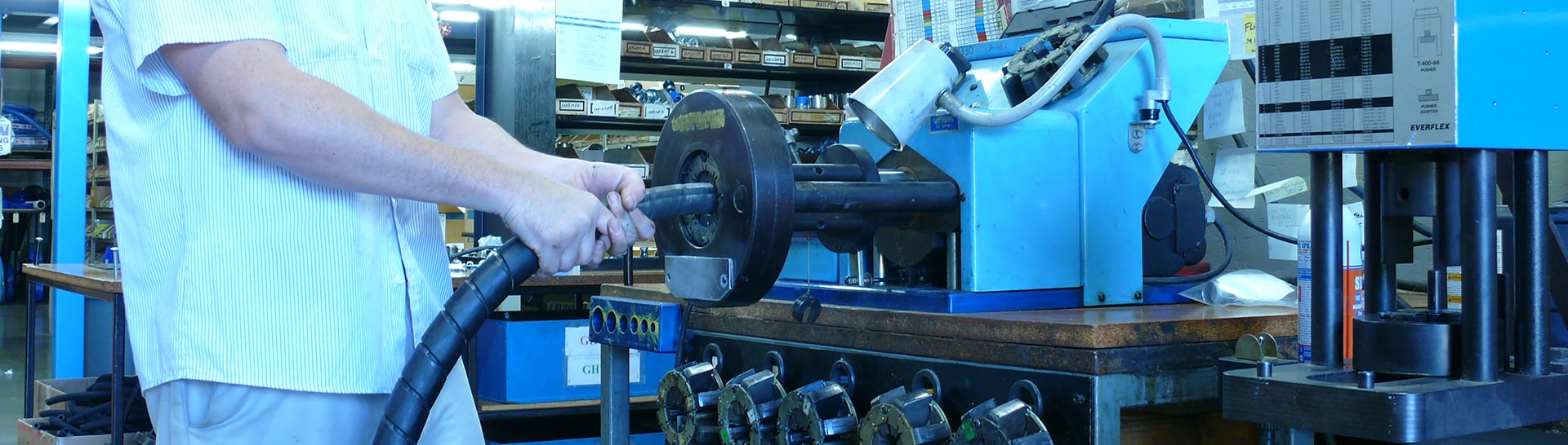 This is an image of a technician installing hose into a machine.